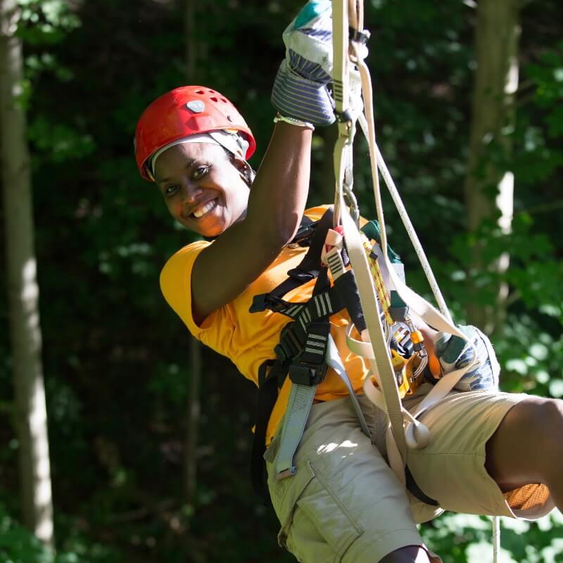 woman smiling while on a zipline tour by common ground canopy tours